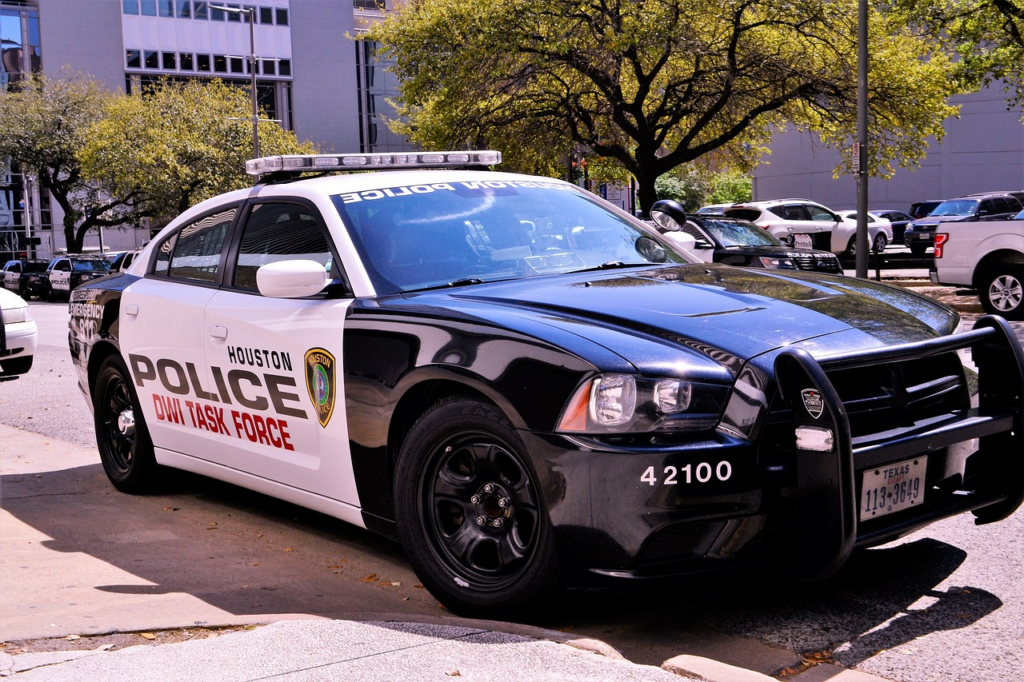 a scene of Broadview Heights Police Department's Accident Reports office, bustling with officers meticulously documenting and organizing stacks of incident files, while a digital display projects real-time accident data onto a wall-mounted screen