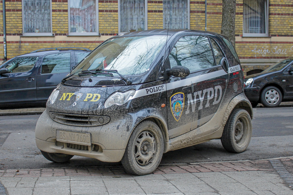 An image capturing the essence of the Accident Report blog post: a sunlit Carpentersville police cruiser parked outside the station, with officers exchanging paperwork and a concerned citizen seeking assistance, emphasizing the community's reliance on accurate accident information